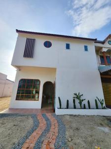 a white house with a brick path in front of it at Baan U Sabai Poshtel (บ้านอยู่สบาย พอสเทล) 