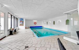 a large swimming pool in a white room with at Hellehave in Ravnholt