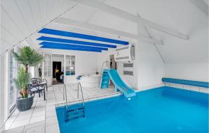 Fjand GårdeにあるNice Home In Ulfborg With 6 Bedrooms, Wifi And Indoor Swimming Poolの家屋内の滑り台付きスイミングプール