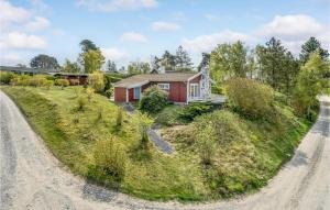 エーベルトフトにあるNice Home In Ebeltoft With 2 Bedrooms And Wifiの未舗装路横の丘の上の家