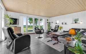 a living room with a table and chairs at Nice Home In Ebeltoft With 3 Bedrooms And Wifi in Ebeltoft