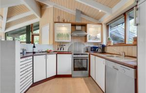 una cocina con armarios blancos y fregadero en Awesome Home In Fjerritslev With 3 Bedrooms, Sauna And Wifi, en Fjerritslev