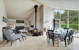 a living room with a table and chairs and a fireplace at 3 Bedroom Awesome Home In Fars in Hvalpsund