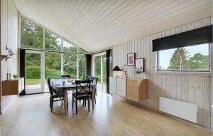 a dining room with a table and chairs and windows at 3 Bedroom Awesome Home In Fars in Hvalpsund