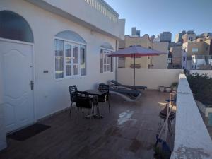 a patio with a table and an umbrella on a balcony at amal's apart&studio in Agadir