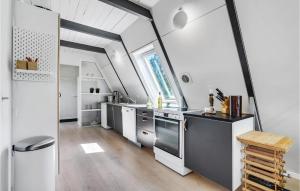 Fjand GårdeにあるStunning Home In Ulfborg With 3 Bedrooms And Wifiの屋根裏のキッチン(白いカウンター、ステンレス製の電化製品付)