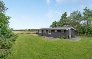 a small house in a field with a yard at Amazing Home In Ebeltoft With 2 Bedrooms And Wifi in Ebeltoft