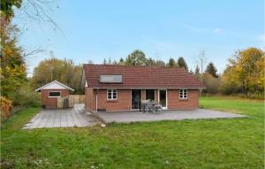 een klein rood bakstenen huis met een patio bij Cozy Home In Herning With Sauna in Herning