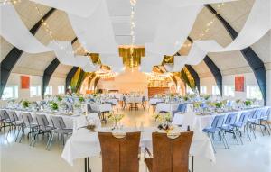 a banquet hall with white tables and blue chairs at Rishj in Hjarbæk