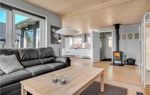 ein Wohnzimmer mit einem schwarzen Sofa und einem Tisch in der Unterkunft 3 Bedroom Lovely Home In Sydals in Skovby