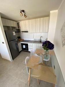 a kitchen with a table and chairs and a refrigerator at Marina Costa in Coquimbo