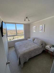 a bedroom with a bed and a large window at Marina Costa in Coquimbo