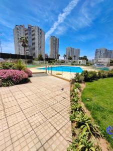 a swimming pool in a park with tall buildings at Marina Costa in Coquimbo