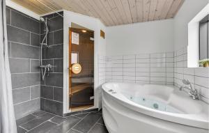 a white bathroom with a tub and a shower at Holiday Home Ellemose in Skovby +20 photos