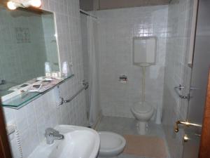a white bathroom with a sink and a toilet at Hotel Eden in Vignola