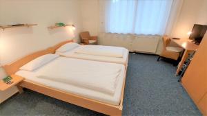 sypialnia z 2 łóżkami i biurkiem w obiekcie Gästehaus TABOR w mieście Marburg