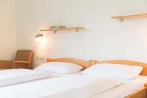 2 łóżka w pokoju z białymi ścianami w obiekcie Gästehaus TABOR w mieście Marburg