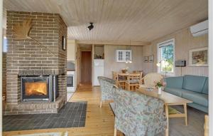 Sønderbyにある2 Bedroom Awesome Home In Juelsmindeのリビングルーム(暖炉、青いソファ付)