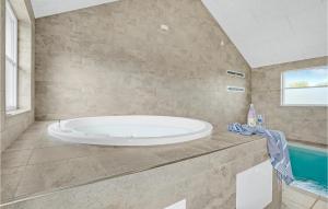a large bathroom with a tub and a swimming pool at Pet Friendly Home In Sydals With Sauna in Høruphav