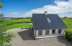 una pequeña casa blanca con un techo negro en un campo en Beautiful Home In Sydals With Wifi en Høruphav