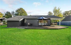 a black house with an umbrella in a yard at Gorgeous Home In Slagelse With Kitchen in Slagelse