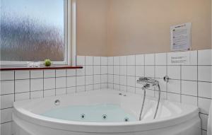 a bath tub in a bathroom with a window at Holiday Home Birkevej Ebeltoft in Øksenmølle +26 photos