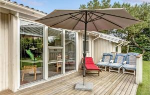 un patio con sombrilla y sillas en una terraza en 4 Bedroom Cozy Home In Sydals, en Skovby