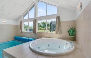 a large white tub in a bathroom with a window at 7 Bedroom Cozy Home In Sydals in Høruphav +20 photos