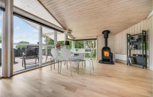 a living room with a table and chairs and a fireplace at Amazing Home In Mårslet With Wifi in Mårslet
