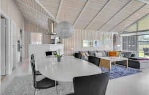 KrejbjergにあるAmazing Home In Ejstrupholm With Kitchenのリビングルーム(白いテーブル、椅子付)