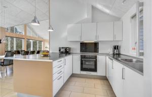 a kitchen with white cabinets and a counter top at Lovely Home In Sydals With Sauna in Høruphav