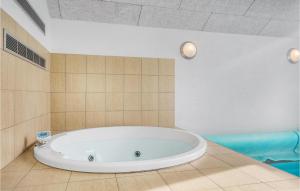 a large bath tub in a bathroom with a tile wall at Lovely Home In Sydals With Sauna in Høruphav
