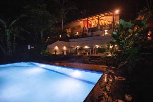 a swimming pool in front of a house at night at Kuru Ganga Villa in Eratnagoda