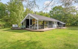 una piccola casa con un ponte e sedie in un cortile di Amazing Home In Ebeltoft With Sauna a Øksenmølle