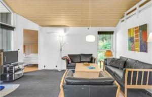 uma sala de estar com um sofá e uma mesa em Amazing Home In Ebeltoft With Sauna em Øksenmølle