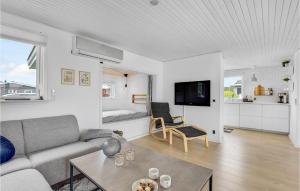 a living room with a couch and a table at Amazing Home In Juelsminde With Kitchen in Sønderby