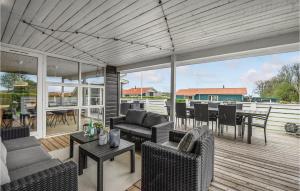 a patio with couches and tables on a deck at Amazing Home In Juelsminde With Kitchen in Sønderby