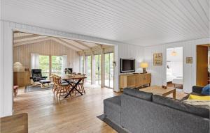 a living room with a couch and a table at Holiday Home Svinget Glesborg Iv in Fjellerup Strand