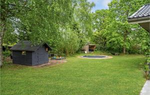a backyard with a dog house and a pond at Holiday Home Svinget Glesborg Iv in Fjellerup Strand +20 photos