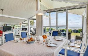 a dining room with a table with food on it at Amazing Home In Bjert With House Sea View in Binderup Strand