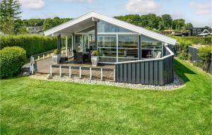 a small house with a deck on a lawn at Amazing Home In Bjert With House Sea View in Binderup Strand