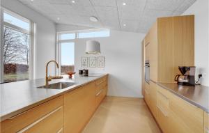 a kitchen with wooden cabinets and a sink at Amazing Home In Sjølund in Sjølund +17 photos