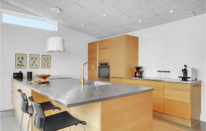 a kitchen with a counter top and wooden cabinets at Amazing Home In Sjølund in Sjølund