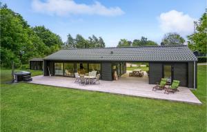 een huis met een terras en een grill in een tuin bij 4 Bedroom Cozy Home In Juelsminde in Juelsminde