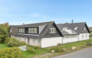 una gran casa blanca con techo negro en Gorgeous Home In Slagelse With Kitchen, en Lille Kongsmark