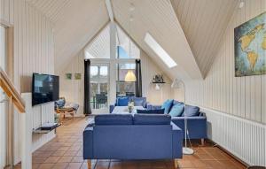 SpodsbjergにあるCozy Home In Rudkbing With Wifiのリビングルーム(青いソファ、テレビ付)