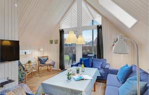 SpodsbjergにあるCozy Home In Rudkbing With Wifiのリビングルーム(青い椅子、テーブル付)