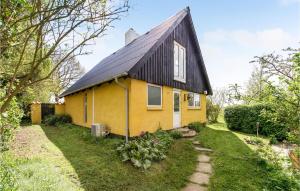 a yellow house with a black roof at Holiday Home Sønderskovvej in Illebølle