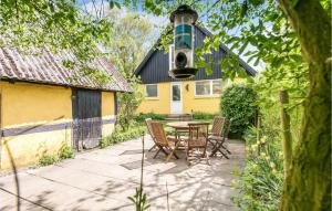 a patio with a table and chairs in front of a house at Holiday Home Sønderskovvej in Illebølle