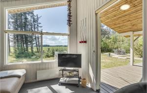GrønhøjにあるBeautiful Home In Lkken With Saunaのリビングルーム(テレビ、大きな窓付)